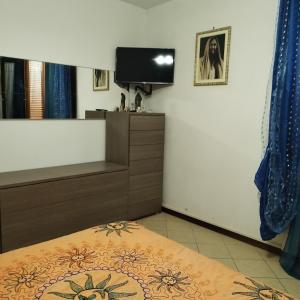 Sunny house Tuscany في La Bandita: غرفة نوم بها سرير وتلفزيون على الحائط