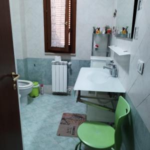 Sunny house Tuscany في La Bandita: حمام مع حوض ومقعد أخضر