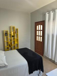 a bedroom with a bed and a window and a door at Suíte - Centro de Itu in Itu +2 photos