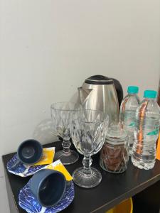 a table with glasses and water bottles on it at Suíte - Centro de Itu in Itu