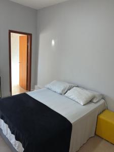 a bed with two pillows on it in a room at Suíte - Centro de Itu in Itu