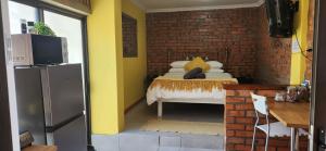 una habitación con una cama y una pared de ladrillo en LyonsDen 1, en Worcester 8 fotos más