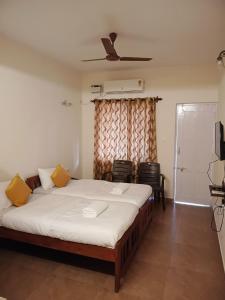 a bedroom with a large bed with yellow pillows at Dona Helena Holiday Home in Madgaon