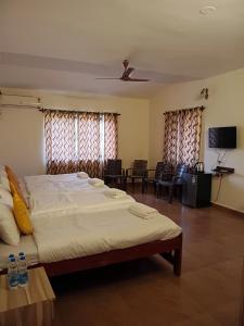 a bedroom with a large bed and a living room at Dona Helena Holiday Home in Madgaon