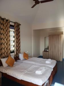 a bedroom with a large bed with two towels on it at Dona Helena Holiday Home in Madgaon