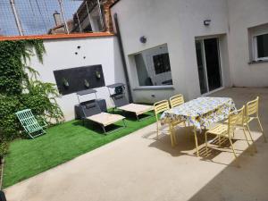 a patio with a table and chairs on grass at Casa Patio del Vino in Ciudad-Rodrigo