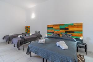 a room with four beds with towels on them at Fiumara Val Di Noto Country Rooms in Noto