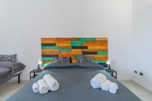 a bedroom with a bed with towels on it at Fiumara Val Di Noto Country Rooms in Noto +83 photos