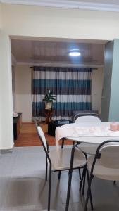 Moya Guesthouse في جوهانسبرغ: غرفة بها طاولة وكراسي وغرفة معيشة