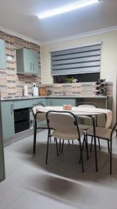 Moya Guesthouse في جوهانسبرغ: مطبخ مع طاولة وكراسي في الغرفة