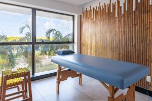a blue table in a room with a large window at BHS Flat a beira mar 2203 in Recife