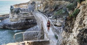 a woman walking down a stairway near the ocean at MOBIL HOME LUXUEUX 40m2 - 3ch - Camping 4 étoiles 79 - LA PIGNADE in La Tremblade