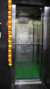 a display case with a green floor and orange sushi at At Home Hotel Darbar in Hyderabad