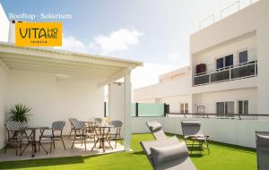 a patio with chairs and tables and a building at Vita Home Lanzarote I Deluxe Apartments in Arrecife