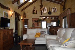 a living room with white couches and a tv at Finca Durillo with private Pool in Cómpeta