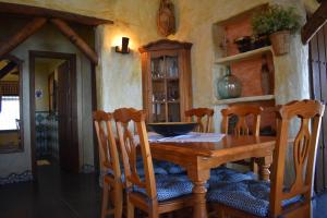 a dining room with a wooden table and chairs at Finca Durillo with private Pool in Cómpeta
