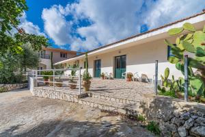 an exterior view of a house with a patio at Fiumara Val Di Noto Country Rooms in Noto