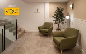 a waiting room with two chairs and a plant at Vita Home Lanzarote I Deluxe Apartments in Arrecife