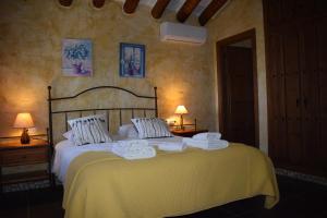 a bedroom with a large bed with towels on it at Finca Durillo with private Pool in Cómpeta +36 photos