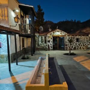 una casa con un edificio de piedra en El Caserio de Araña, Cercados de Araña, en Los Cercados