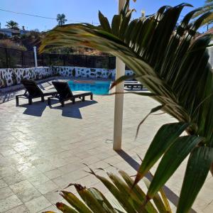 two benches sitting next to a swimming pool at El Caserio de Araña, Cercados de Araña in Los Cercados