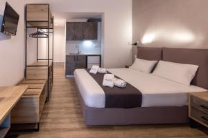 a bedroom with a large bed and a kitchen at Azzurro in Nei Poroi