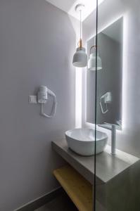 a bathroom with a white sink and a mirror at Azzurro in Nei Poroi +22 photos