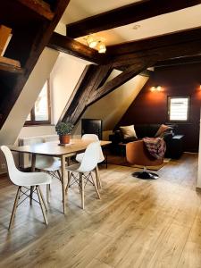 una sala da pranzo con tavolo, sedie e divano di T2 cosy charme alsacien poutres apparentes au centre de Barr a Barr