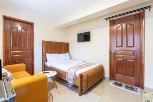 Un dormitorio pequeño con una cama, un sofá y un televisor. en Hazel Studio with free WI-FI, en Nanyuki