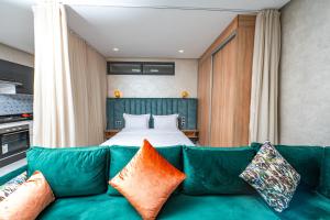a living room with a green couch and a bed at maarif elite suite in Casablanca