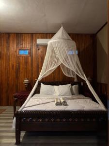 a bed with two pairs of shoes on top of it at Khailash Warung and Home Stay in Sidemen +30 photos