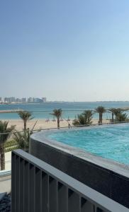 een zwembad met een strand op de achtergrond bij Marrasi Vista by the address in Muharraq