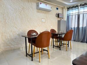 a dining room with tables and chairs and a wall at The Mayfair Hotel in Jāmb
