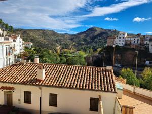 ein Gebäude mit einem Kacheldach mit Bergen im Hintergrund in der Unterkunft Casa del Convento II in Montán