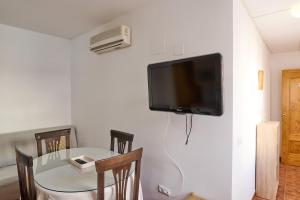 a dining room table with a television on a wall at Seralva Rural Zuheros in Zuheros