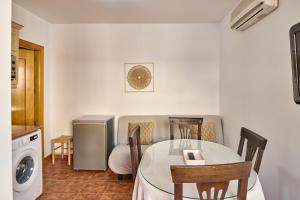 a kitchen with a table and chairs and a washing machine at Seralva Rural Zuheros in Zuheros