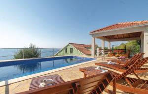 une piscine avec deux chaises et une maison dans l'établissement Apartman Mario with pool by Villas Guide, à Potirna