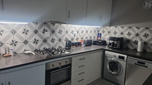 a kitchen with a stove and a washing machine at Magents the Farm in Paarl