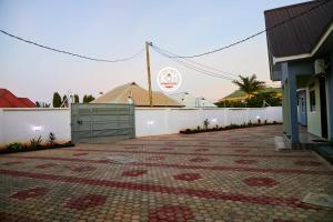 eine Ziegelterrasse mit weißem Zaun und einem Gebäude in der Unterkunft Kwangu Homes Dodoma Collection in Dodoma