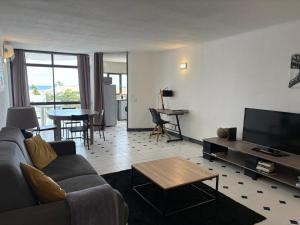 een woonkamer met een bank, een tv en een tafel bij Coral By Albufeira Rental in Albufeira