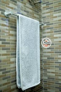 ein Handtuch, das in einer Dusche an der Wand hängt in der Unterkunft Kwangu Homes Dodoma Collection in Dodoma