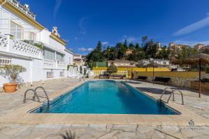 una piscina frente a un edificio blanco en Living4Malaga Sky Garden Duplex, en Málaga