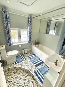 a bathroom with a tub and a toilet and a sink at Charming 3 bed kent Cottage in Chilham +17 photos