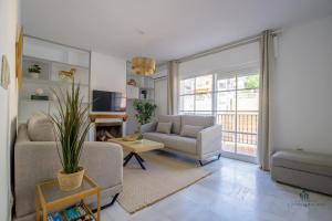 Sala de estar con 2 sofás, sofá y mesa en Living4Malaga Sky Garden Duplex, en Málaga