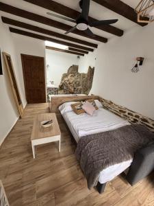 ein Schlafzimmer mit einem Bett und einem Tisch in der Unterkunft El Tumbao con romántica bañera de hidromasaje para dos in Laroya