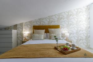 Un dormitorio con una cama grande con cabecero de madera. en Living4Malaga Sky Garden Duplex, en Málaga 21 fotos más