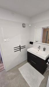 een witte badkamer met een wastafel en een spiegel bij Dom Hlohovec Center in Hlohovec +19 foto's