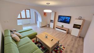 een woonkamer met een groene bank en een tafel bij Dom Hlohovec Center in Hlohovec