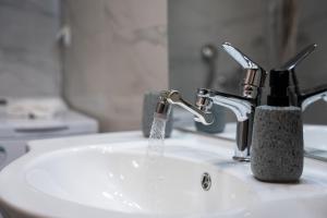 a bathroom sink with water coming out of a faucet at Spyridoula House in Corfu +14 photos