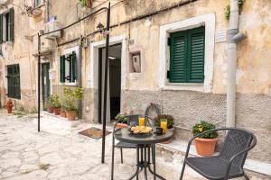 a table and chairs in front of a building at Spyridoula House in Corfu